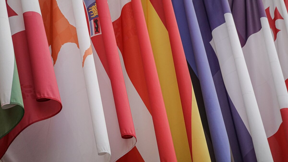 Vibrant display of various international flags closely hanging together.