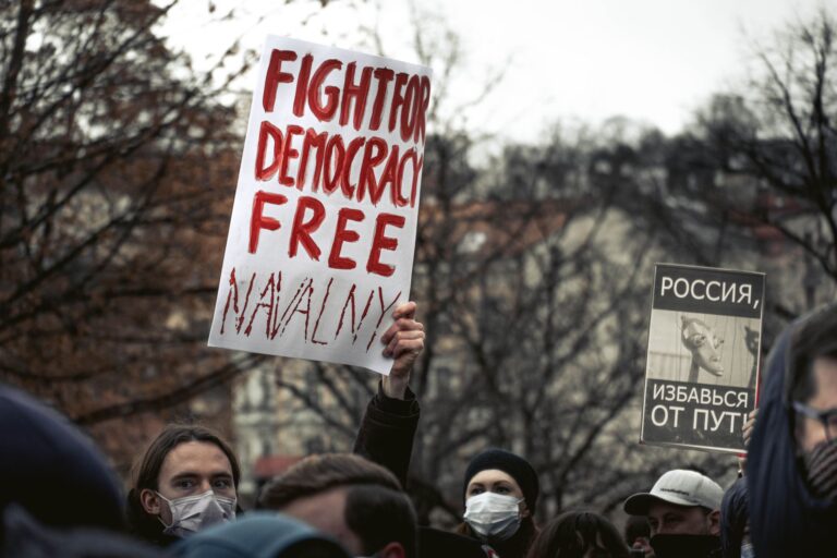 Demonstrators in Prague holding signs advocating for political change and democracy.